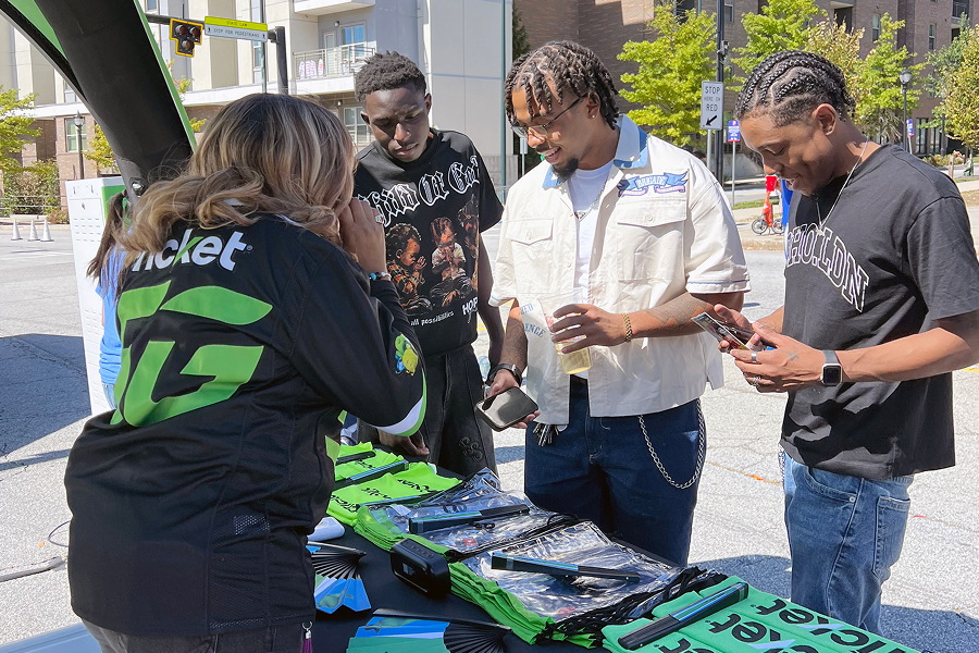Cricket Wireless brand ambassador handing out promotional merchandise to Georgia State University students at an outdoor campus activation