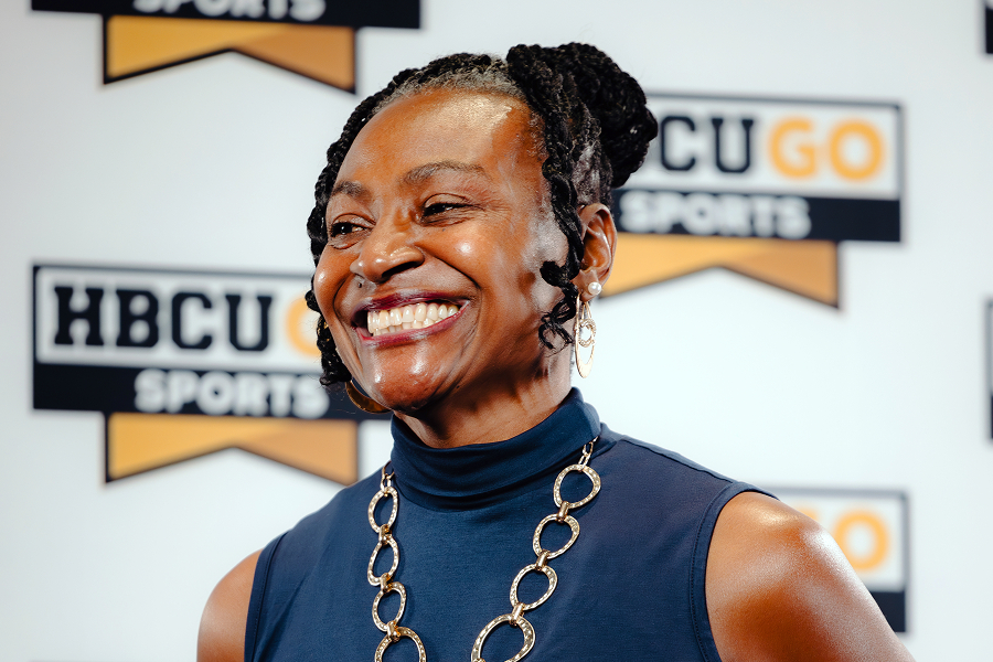 Smiling woman posing at an HBCU Go Sports media event backdrop