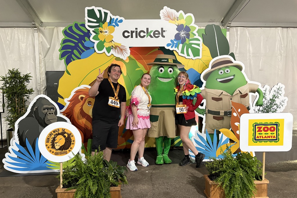 Run Like Wild 5K runners posing with Cricket characters at the Cricket and Zoo Atlanta photo booth